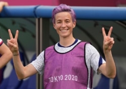 United States' Megan Rapinoe gives the victory sign before a women's soccer match against Sweden at the 2020 Summer Olympics, July 21, 2021, in Tokyo.