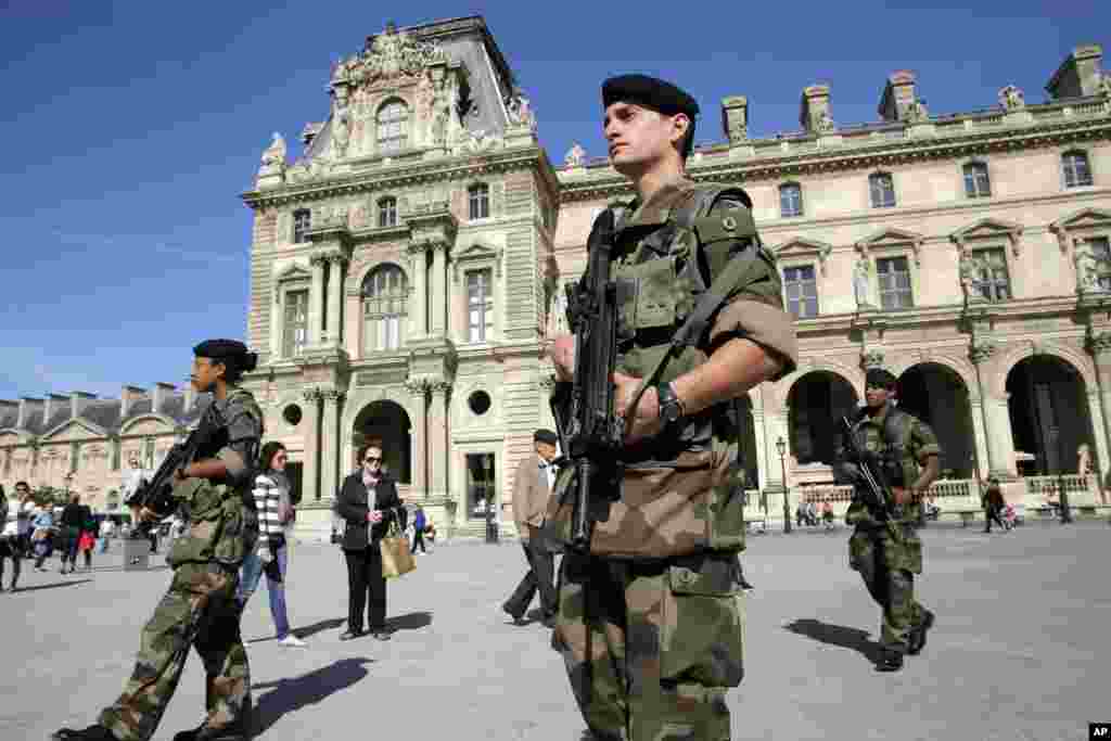 Soldiers patrol through the courtyard of the Louvre museum, in Paris, Sept. 26, 2014.