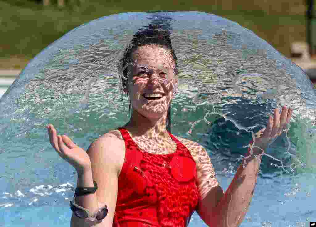 A woman refreshes herself at an outdoor pool in Ehingen, Germany.