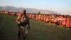 A member of the protection service keeps watch as women dance during the last day of the eight-day Reed Dance at Ludzidzini Royal Palace in Swaziland, Aug. 31, 2015. 