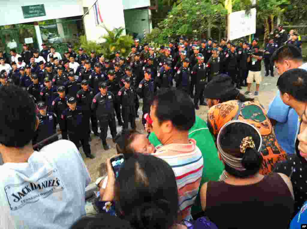 Protesters and onlookers watch Thai police and soldiers line up in front of disputed flood gate at Samwa canal, Bangkok, October 31, 2011. (VOA)