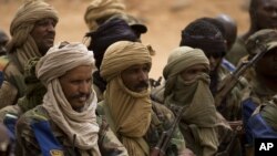 FILE - FILE - In this July 27, 2013 file photo, Malian Tuareg soldiers loyal to Col. Major El-Hadj Gamou listen during a visit by Mali's army chief of staff in Kidal, Mali. 