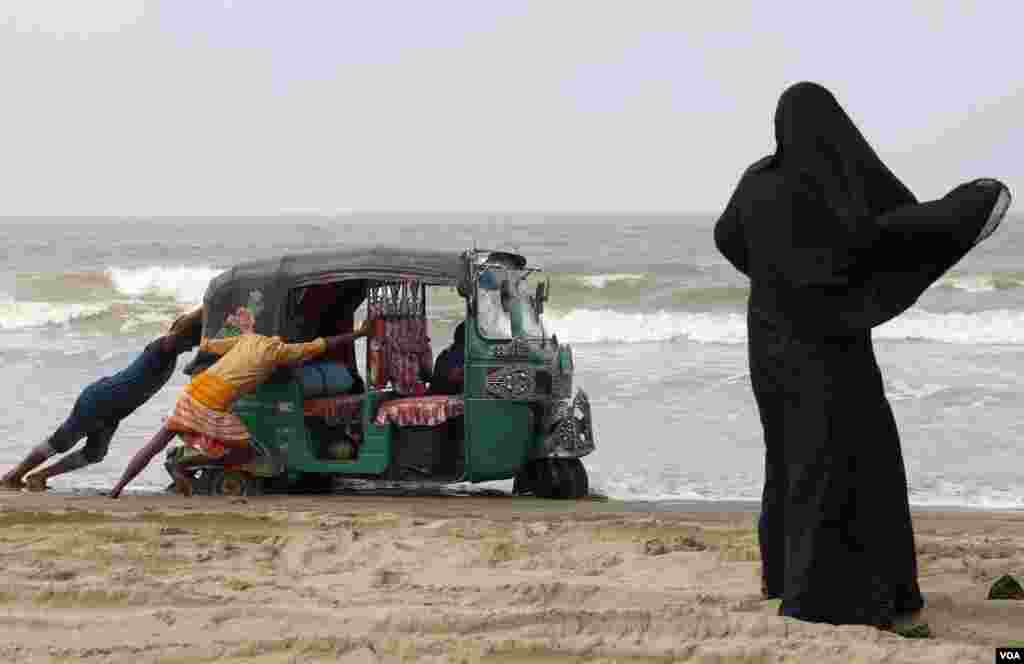 Passengers push a rickshaw called CNG that was stuck in the beach of Cox&rsquo;s Bazar April 4, 2019. Tum-tums and CNGs are among the most popular modes of transportation in Bangladesh. (Hai Do/VOA)