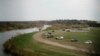 FILE - U.S. border patrol cars are seen through the fence of the bridge connecting Eagle Pass, Texas, with Piedras Negras, Mexico, near the banks of Rio Bravo, from Piedras Negras, Mexico, Feb. 7, 2019. 