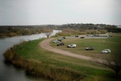 FILE - U.S. border patrol cars are seen through the fence of the bridge connecting Eagle Pass, Texas, with Piedras Negras, Mexico, near the banks of Rio Bravo, from Piedras Negras, Mexico, Feb. 7, 2019.