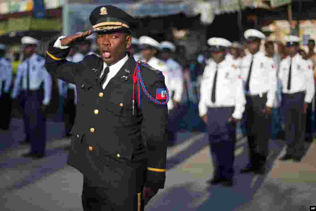 National police officer Shatner Jean salutes during a ceremony marking the 208th anniversary of the assassination of Haiti&#39;s independence hero and founding father Jean-Jacques Dessalines, in Port-au-Prince, Haiti. 