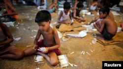 Children fill up empty cigarettes packs manually with locally grown tobacco in a small factory in Bangladesh, in this July 2013 file photo. 