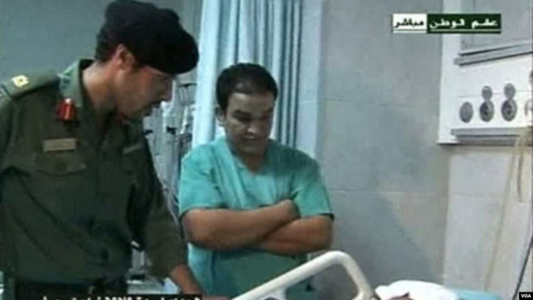 Gambar dari televisi pemerintah Libya ini menunjukkan Khamis Gaddafi (kiri) masih hidup, dan sedang mengunjungi warga Libya yang terluka di sebuah rumah sakit.