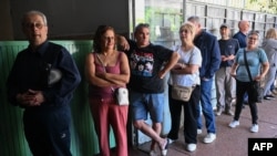 La gente hace cola para votar durante las elecciones presidenciales y legislativas, en Canelones, Uruguay, el 27 de octubre de 2024.