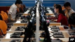 FILE - North Korean men and women use computer terminals at the Sci-Tech Complex in Pyongyang, N. Korea, June 16, 2017. On Feb. 16, 2021, S. Korea's intelligence service said N. Korean hackers attempted to steal information about coronavirus vaccines.