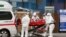 A confirmed coronavirus patient is wheeled to a hospital at Chuncheon, South Korea, Feb. 22, 2020.