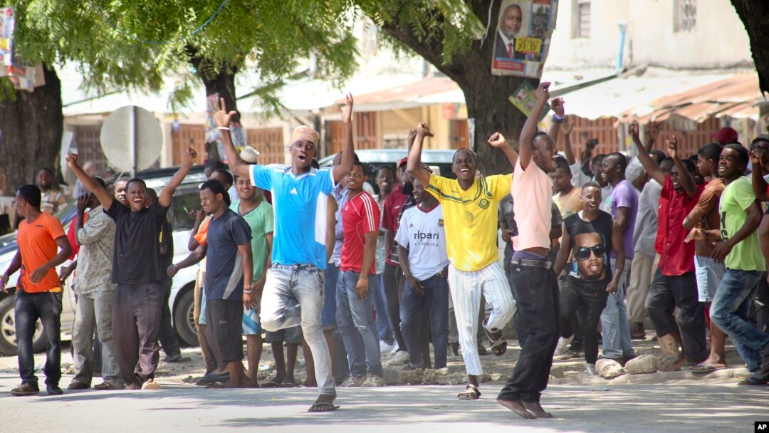In this photo taken Monday, Oct. 26th, 2015 and made available Wednesday, Oct. 28th, 2015, youths supporting the opposition party dance and chant, predicting a win for their candidate, outside the Electoral Commission office in Stone Town, Zanzibar.