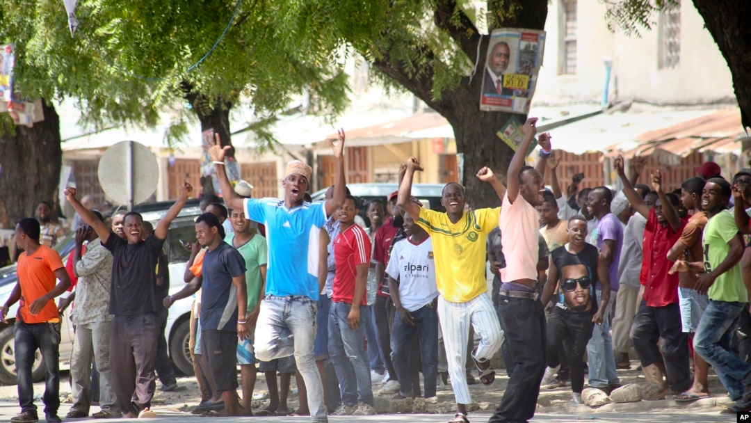 FILE - In this photo taken Oct. 26, 2015, youths supporting the opposition party dance and chant, predicting a win for their candidate, outside the Electoral Commission office in Stone Town, Zanzibar, a semi-autonomous island archipelago of Tanzania. Zanzibar is preparing for an election rerun Sunday, after polls were nullified in the region last year. 