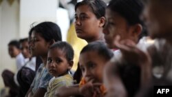 Rakhine families stay at a monastery used as a temporary shelter for people displaced by days of violence in Sittwe, capital of the western state of Rakhine, Burma, June 14, 2012.