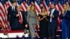 Former US President and Republican presidential candidate Donald Trump gestures at supporters after speaking as he holds hands with former US First Lady Melania Trump during an election night event at the West Palm Beach Convention Center in West Palm Bea