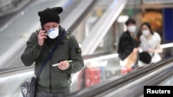 Las máscaras faciales ya llegaron a Italia. Los pasajeros se protegen contra la infección de coronavirus en la estación cental de trenes de Milán el 24 de febrero de 2020.