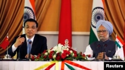 Chinese Premier Li Keqiang (L) speaks with the media as India's Prime Minister Manmohan Singh looks on during the signing of agreements ceremony in New Delhi, May 20, 2013. 