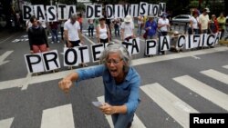 Opposition supporters hold letters to build a banner that reads "Stop dividing. Peaceful protest", during a rally against Venezuelan President Nicolas Maduro's government in Caracas, Venezuela, June 17, 2017. 