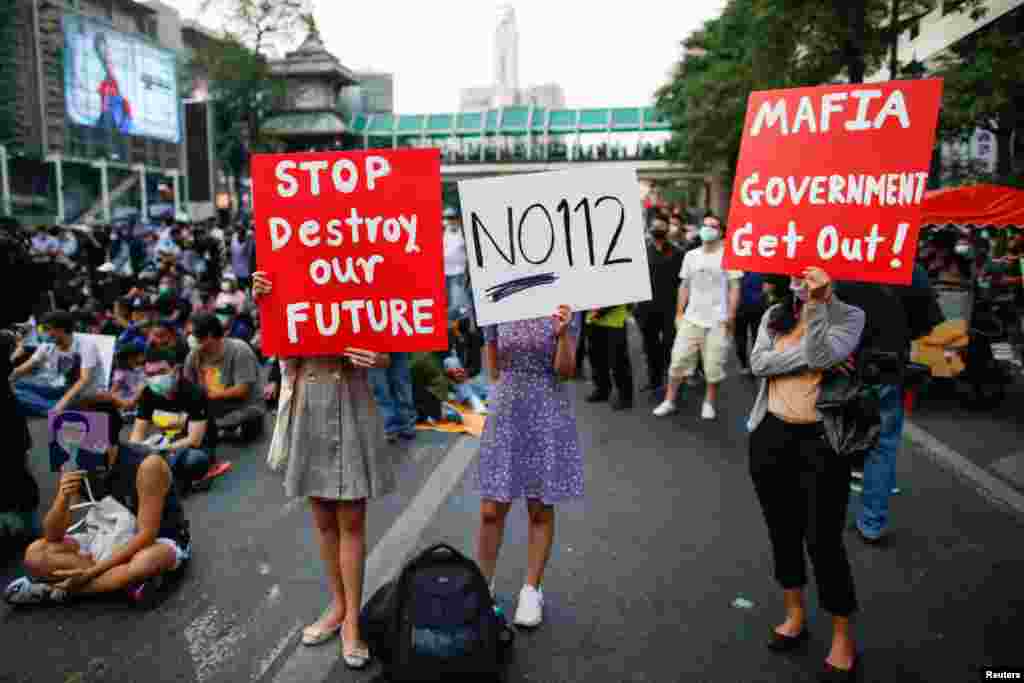 Pro-democracy protesters hold signs during a rally demanding the release of arrested protest leaders and the abolition of 112 lese majeste law, in Bangkok, Thailand.