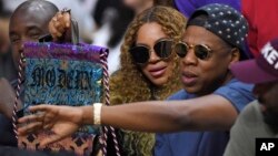 FILE - Beyonce and Jay Z watch during the first half in Game 7 of an NBA basketball first-round playoff series between the Los Angeles Clippers and the Utah Jazz, April 30, 2017, in Los Angeles. 