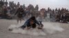 Dua pria Afghanistan adu gulat di hadapan para penonton,di taman Chaman-e-Huzori, Kabul, Afghanistan, Jumat, 3 Desember 2021. Adu gulat tradisional yang menarik perhatian banyak orang ini, digelar setiap minggu, selepas salat Jumat. 