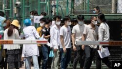 Residents line up to get tested at a coronavirus testing center set up outside a sports facility in Beijing, June 16, 2020. 