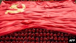 Estudiantes universitarios exhiben la bandera del Partido Comunista de China para conmemorar el centenario del partido durante una ceremonia de apertura del nuevo semestre en Wuhan, en el centro de Hubei, China, el 10 de septiembre de 2021.