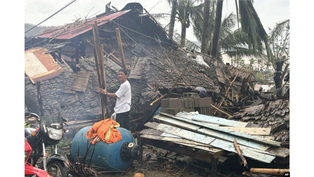 Seorang warga berdiri di samping rumah yang rusak akibat Topan Man-yi di Viga, Provinsi Catanduanes, timur laut Filipina, Minggu, 17 November 2024. (MDRRMO Viga Catanduanes via AP)