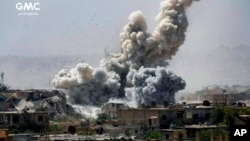 This photo provided Monday, Sept 25, 2017, by the Ghouta Media Center, a Syrian activist media group, shows smoke and debris rising after Syrian government shelling of the rebel-held Jobar neighborhood of Damascus, Syria.