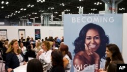 FILE - A poster for former first lady Michelle Obama's memoir, Becoming, is displayed in the Penguin Random House exhibit at Book Expo in New York, May 31, 2018.