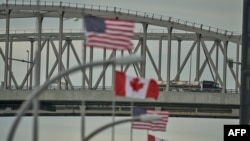 A truck crosses the U.S.-Canada Bluewater Bridge border crossing between Sarnia, Ontario, and Port Huron, Michigan, March 16, 2020. The border between the two countries is now closed to non-essential travel. 