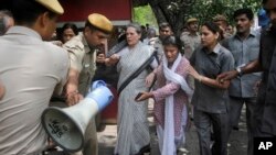 India's opposition Congress party president Sonia Gandhi, second left, is escorted by her security personnel as she leads a march against the ruling Bharatiya Janata Party (BJP) government in New Delhi, India on May 6, 2016.