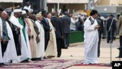 Libyan leader Moammar Gadhafi (R) prays during the celebration of the birth of the Prophet in Uganda's capital, Kampala, on March, 19, 2008 along with the Ugandan president and other African leaders.