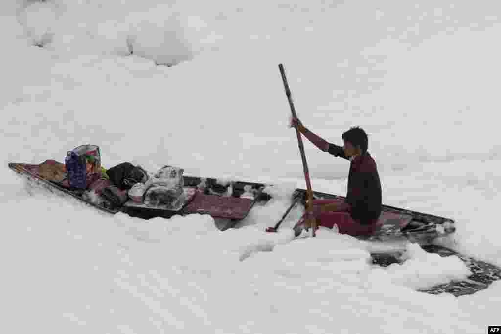 A man rows his boat in the polluted Yamuna River on the outskirts of New Delhi, India.
