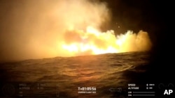 This image provided by SpaceX shows smoke and fire from SpaceX's mega Starship rocket after landing in the water in the Indian Ocean after returning during a test flight, Oct. 13, 2024. (SpaceX via AP)