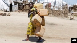 FILE - A girl displaced by Islamist extremists carries empty plastic containers at a camp Maiduguri, Nigeria, Aug. 28, 2016.