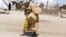FILE - A girl displaced by Islamist extremists carries empty plastic containers at a camp Maiduguri, Nigeria, Aug. 28, 2016.