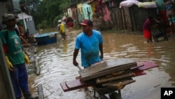 Residents clean out their flooded homes in Itapetinga, Bahia state, Brazil, Dec. 28, 2021. 