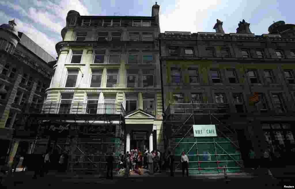 Pedestrians gather outside scaffoldings built to protect two shops from an intense beam of sunlight reflected off the Walkie Talkie tower in central London. The Walkie Talkie tower that reflects sunlight at an intensity capable of melting parts of a car became the latest attraction in the city&#39;s financial district as the developers acted to find a quick fix.