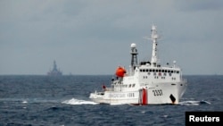 Kapal penjaga pantai China siaga di dekat anjungan minyak China di laut China Selatan yang terlihat di latar belakang (foto: dok).