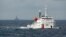 FILE - A Chinese Coast Guard vessel, with a disputed oil rig in the background, is seen in the South China Sea June 13, 2014.