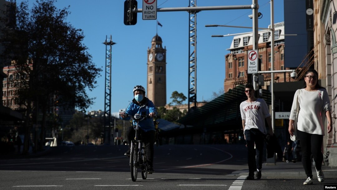 Seorang kurir dan para pejalan kaki di pusat kota menyusul pelonggaran sejumlah pembatasan terkait pandemi virus corona (Covid-19) di Sydney, Australia, Juni 2020. 