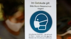 FILE - A sign advising people to wear face masks is seen at the Protestant high school Zum Grauen Kloster, on the first day of classes after the summer holidays, amid the coronavirus disease pandemic, in Berlin, Germany, Aug. 10, 2020.