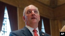 FILE - Louisiana Gov. John Bel Edwards recites the Pledge of Allegiance at the opening of the annual state legislative session in Baton Rouge, April 8, 2019.