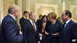 From left, Belarusian President Alexander Lukashenko, Russian President Vladimir Putin, German Chancellor Angela Merkel, French President Francois Hollande talk in Minsk, Belarus, Feb. 11, 2015. 