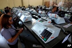 FILE - Electoral Court employees work on the final stage of sealing electronic voting machines in preparation for the general election run-off in Brasilia, Brazil, Oct. 19, 2022, ahead of the Oct. 30 second round vote.