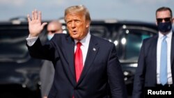 FILE - U.S. President Donald Trump waves as he arrives at Palm Beach International Airport in West Palm Beach, Fla., Jan. 20, 2021. 