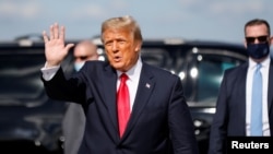FILE - U.S. President Donald Trump waves as he arrives at Palm Beach International Airport in West Palm Beach, Fla., Jan. 20, 2021. 