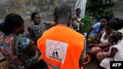 Un agent de recensement s'entretient avec les membres d'une famille dans le quartier de Yopougon à Abidjan en Côte d'Ivoire, le 24 avril 2014. AFP / Sia Kambou