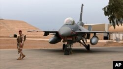 FILE - An Iraqi soldier stands guard near a U.S.-made Iraqi air force F-16 jet at Balad Air Base, north of Baghdad, Iraq, Feb. 13, 2018. 